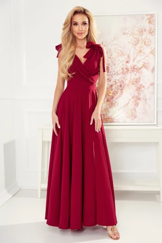 Dlouhá vínová šaty s elegantním zavinovacím výstřihem a ozdobnými mašlemi na ramenou. Sukně je splývavá a dodává šatům sofistikovaný vzhled.}