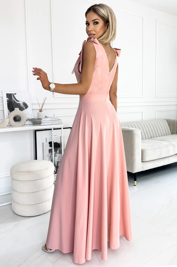 Dlouhá růžová šaty s elegantním střihem a hlubokým výstřihem na zádech. Šaty mají jemné plisování, které dodává objem a pohyb.