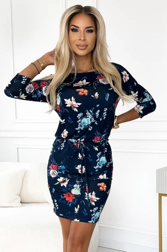 Na obrázku je elegantní sportovní šaty s květinovým vzorem na tmavě modrém pozadí. Šaty mají tříčtvrteční rukávy a jsou doplněny šňůrkou v pase pro zvýraznění siluety.}