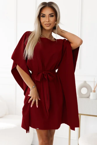 Na obrázku je elegantní dámské šaty v sytě červené barvě s volnými rukávy a páskem v pase. Šaty mají jednoduchý, ale sofistikovaný střih, který zdůrazňuje ženskou postavu.}