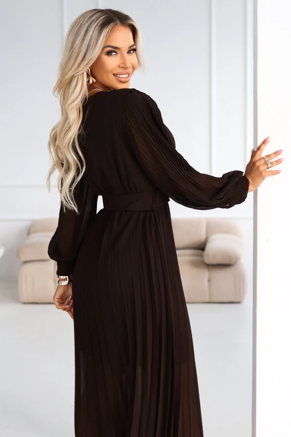 Elegancka sukienka plisowana w kolorze czekoladowym – modelka pokazuje fason z długim rękawem, kopertową górą i podkreśloną talią.