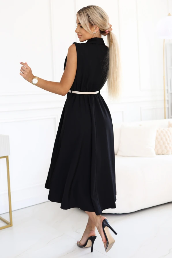 Modelka prezentuje czarną elegancką sukienkę midi bez rękawów z ozdobnymi guzikami i beżowym paskiem w talii od Numoco Basic, stojąc w jasnym, nowoczesnym wnętrzu. Stylowa, klasyczna propozycja idealna na lato, spotkania i codzienne stylizacje.