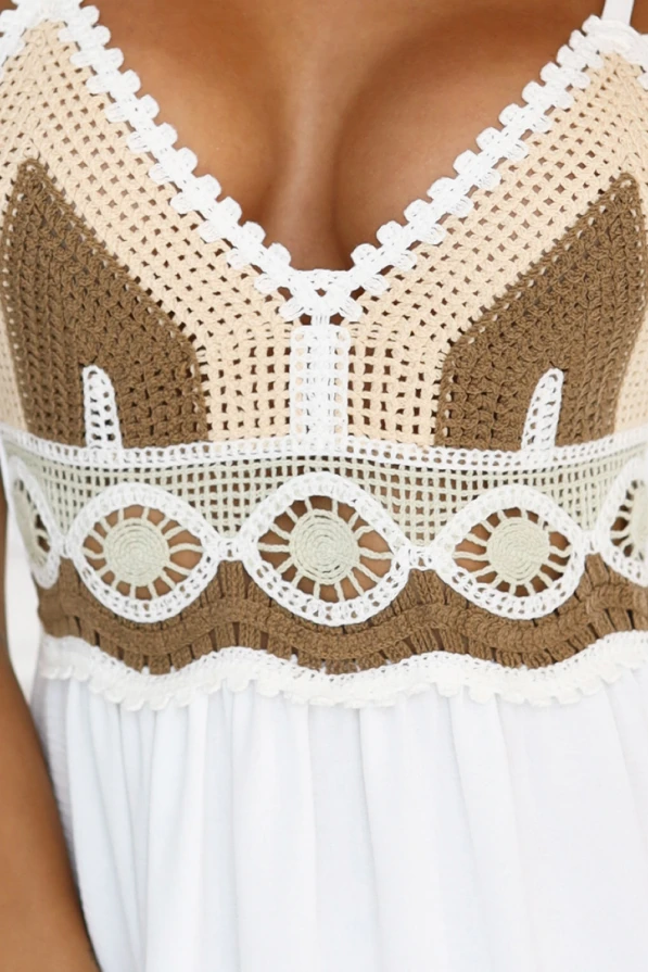 Modelka prezentuje letnią sukienkę maxi na ramiączkach w stylu boho od Numoco Basic – z ażurowym brązowo-kremowym topem i rozkloszowanym dołem w odcieniach bieli i beżu. Idealna stylizacja na wakacje, plażę lub letni spacer.