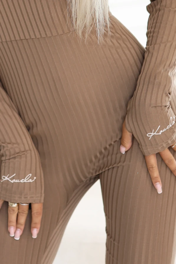 Dopasowany kombinezon damski w kolorze beżowym z elastycznej prążkowanej dzianiny