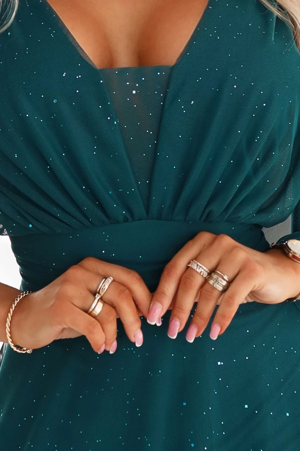 Modelka w długiej zielonej sukience plus size z tiulową warstwą i taliowaniem – stylowa kreacja wieczorowa idealna na wesele i galę.