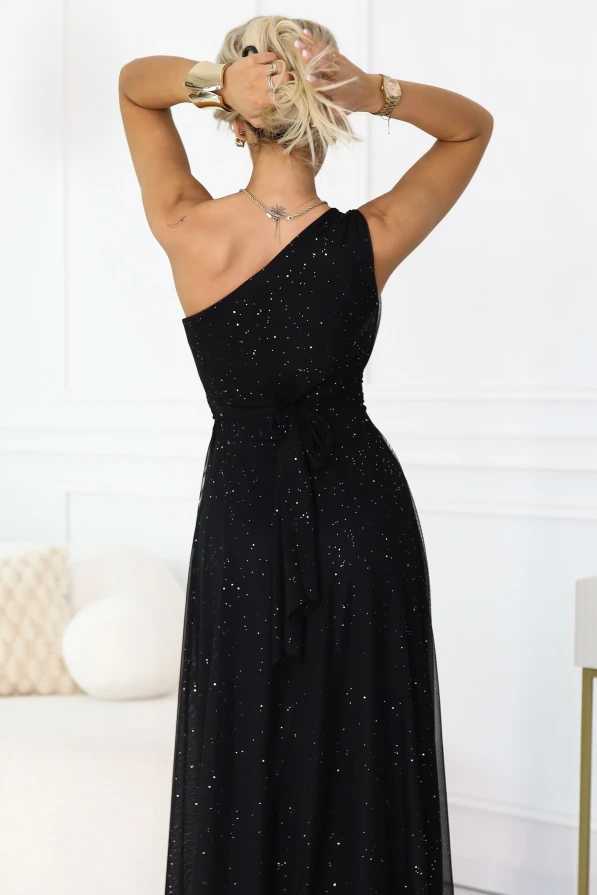 Tył czarnej brokatowej sukienki maxi na jedno ramię Numoco Basic, wiązanie w talii i zwiewna spódnica